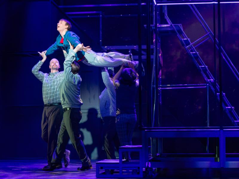 boy being held up by three stagehands